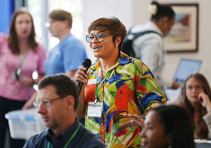 Photo of a woman attendee speaking into a microphone at the Gig East Summit
