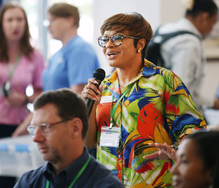 Photo of a woman attendee speaking into a microphone at the Gig East Summit