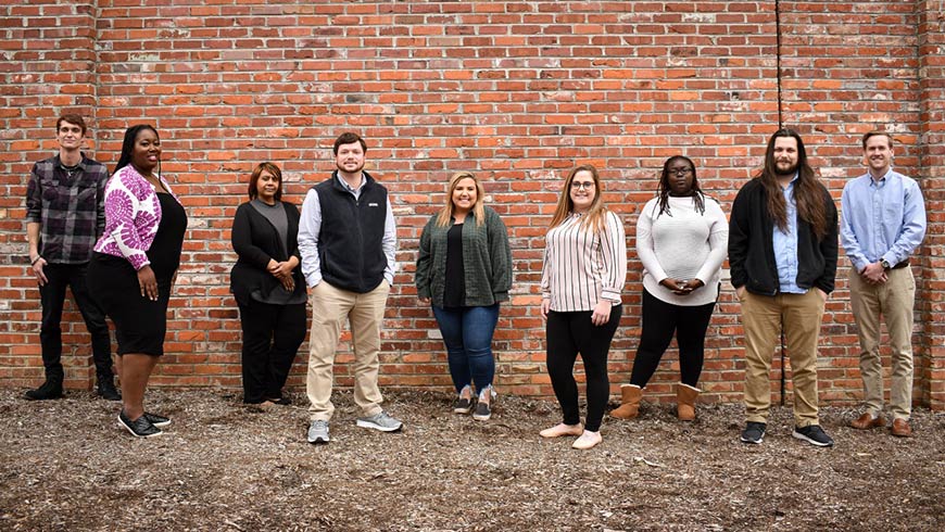 Photo of the North State Consulting team standing in front of a brick wall
