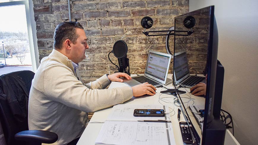 Photo of Marcus Aman of Shyft Auto sitting at a desk using a laptop